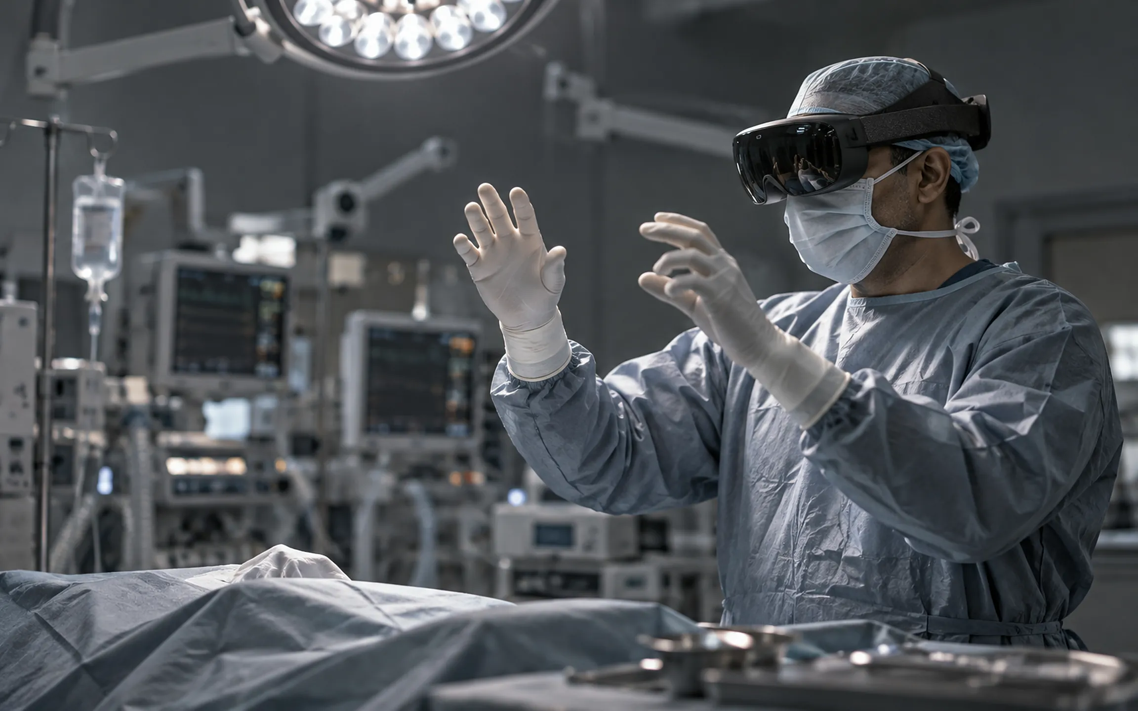 A surgeon in an AR visor and gloves, hands raised, in an operating theatre